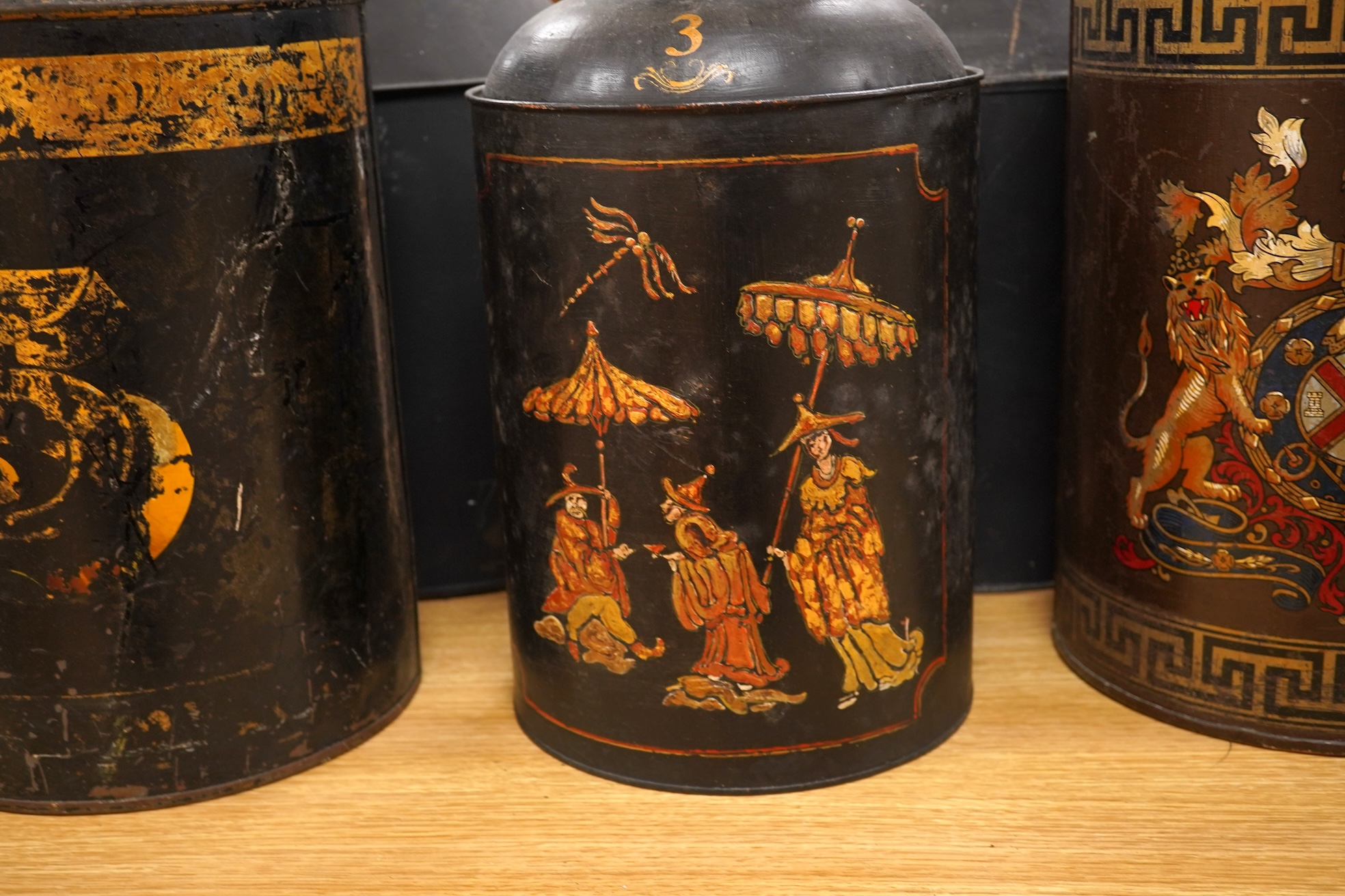 Five 19th century toleware tea canisters, largest 43cm